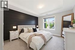 Bedroom featuring a shiplap accent wall, white trim, recessed ceiling, and a large window with exterior visibility - 