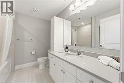 Bathroom vanity with a light gray countertop, undermount sink, and chrome faucet - 