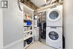 Laundry area featuring a stacked washer and dryer, utility shelving, and a water heater - 