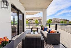 Private outdoor terrace featuring a concrete surface, overhead ceiling, and black-framed sliding glass doors - 