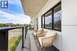 Private balcony featuring a concrete floor, glass railing, and modern exterior paneling - 