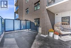 Spacious outdoor patio featuring dark concrete flooring and contemporary frosted glass privacy panels with black framing - 