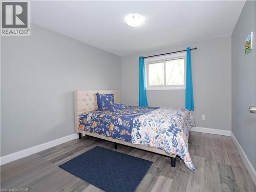 Room featuring light grey walls, white baseboards, and wood-finish flooring - 771 Monsarrat Avenue, London, ON 