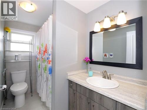 Bathroom featuring a vanity with a light wood-finish cabinet and a stone-look countertop - 771 Monsarrat Avenue, London, ON 