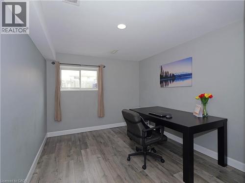 Room featuring light gray walls, wood-finish flooring, a window with a white frame, and a recessed ceiling light - 771 Monsarrat Avenue, London, ON 