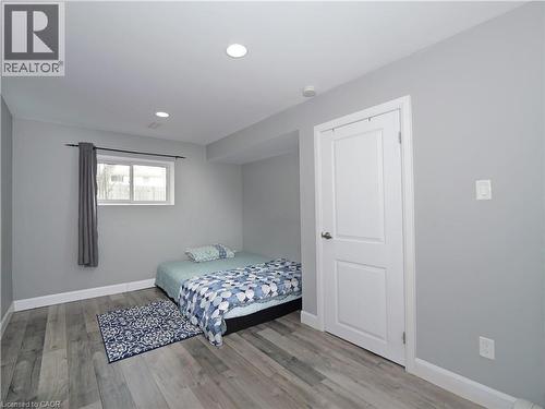 Room featuring wood-finish flooring, recessed lighting, and a white paneled door - 771 Monsarrat Avenue, London, ON 