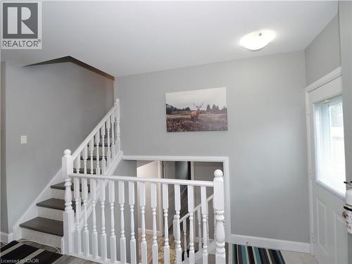 Staircase featuring dark wood-finish treads, white balusters, and light gray wall paint - 771 Monsarrat Avenue, London, ON 