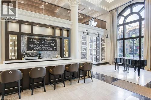 Lobby area featuring a built-in bar with dark wood cabinetry, white countertop, and mosaic tile backsplash - 112 King Street E Unit# Ph6, Hamilton, ON - Indoor Photo Showing Dining Room
