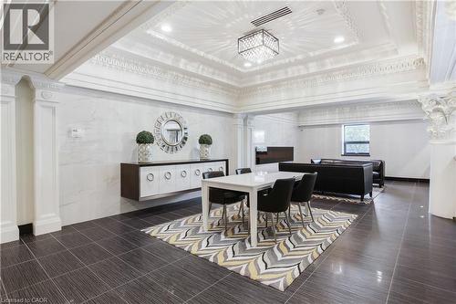 Spacious common area featuring decorative crown molding, recessed lighting, a modern chandelier, dark tile flooring, and a window providing natural light - 112 King Street E Unit# Ph6, Hamilton, ON - Indoor Photo Showing Dining Room