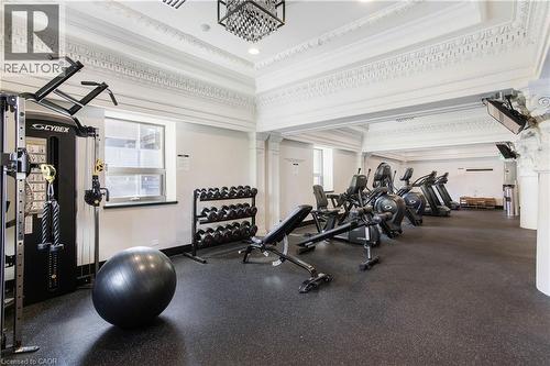 Fitness center featuring durable rubber flooring, extensive cardio equipment, a comprehensive weight machine, and dumbbell rack - 112 King Street E Unit# Ph6, Hamilton, ON - Indoor Photo Showing Gym Room