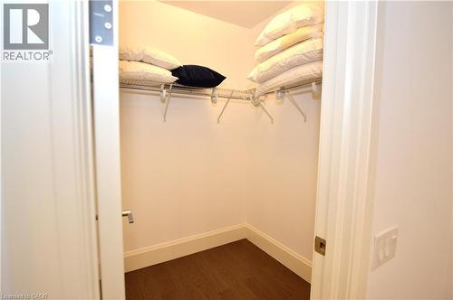 Walk-in closet featuring wire shelving, dark wood-finish flooring, and white baseboards - 112 King Street E Unit# Ph6, Hamilton, ON - Indoor Photo Showing Other Room