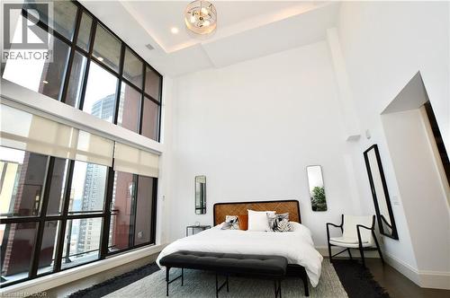 Soaring ceilings and expansive multi-story windows define this bedroom space - 112 King Street E Unit# Ph6, Hamilton, ON - Indoor Photo Showing Bedroom