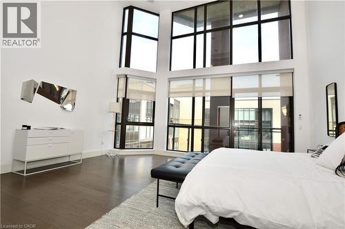 Vaulted ceilings in an interior space featuring tall, multi-pane windows with dark framing - 112 King Street E Unit# Ph6, Hamilton, ON - Indoor Photo Showing Bedroom