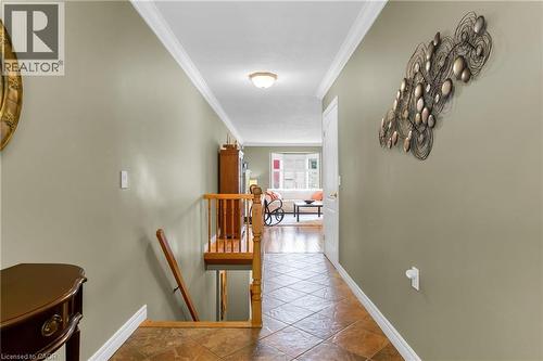 Hallway featuring wood-finish railing and tiled flooring - 50 Spadara Drive, Hamilton, ON 