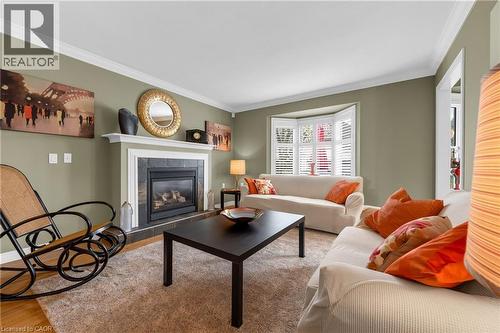 Living area featuring a gas fireplace with a stone surround and white mantel - 50 Spadara Drive, Hamilton, ON 