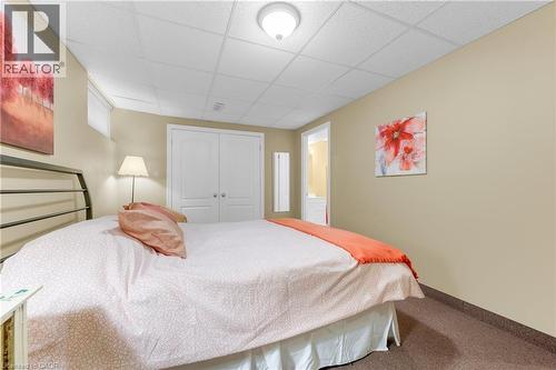 Carpeted room featuring neutral-toned walls, a drop ceiling, and a flush-mount ceiling light - 50 Spadara Drive, Hamilton, ON 