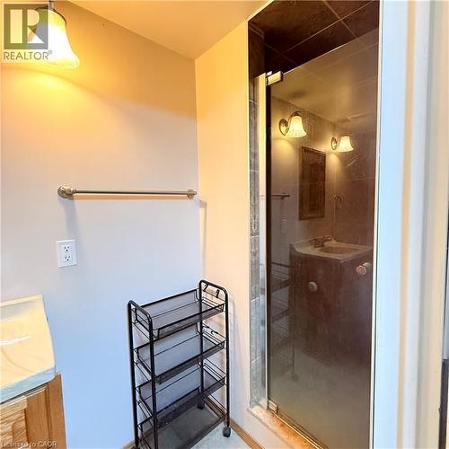 Bathroom featuring a glass-enclosed shower, wall-mounted light fixtures, and a polished chrome towel bar - 82 Blackwood Crescent, Hamilton, ON 