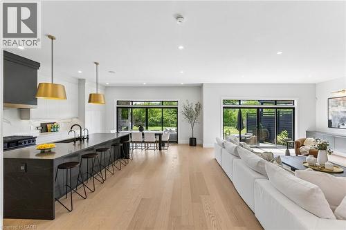 Open-concept living space featuring custom designer kitchen with 10' island clad in quartz countertop with waterfall edge and breakfast bar - 95 Pondcliffe Drive, Kitchener, ON 