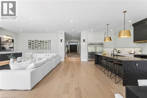 Open-concept living space featuring wide-plank wood-finish flooring, recessed lighting, and a contemporary kitchen - 95 Pondcliffe Drive, Kitchener, ON 