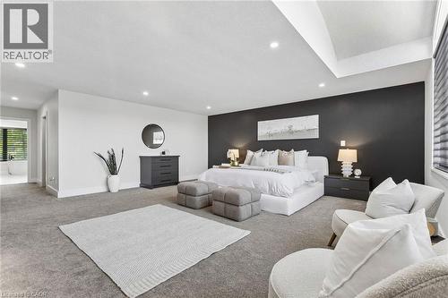 Spacious room featuring a dark accent wall, recessed lighting, and tray ceiling detail - 95 Pondcliffe Drive, Kitchener, ON 