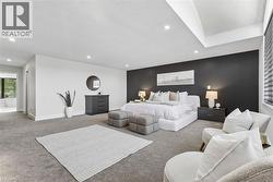 Spacious room featuring a dark accent wall, recessed lighting, and tray ceiling detail - 