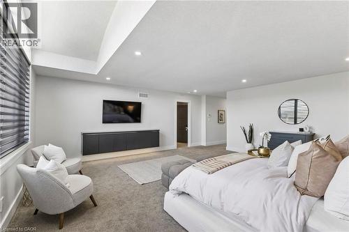 Spacious room featuring vaulted ceilings with recessed lighting, plush carpeting, and light-filtering window treatments - 95 Pondcliffe Drive, Kitchener, ON 