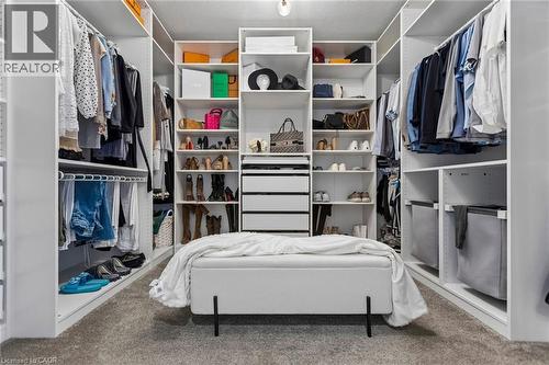 Custom closet system featuring extensive shelving, multiple hanging rods, integrated drawers, and a central storage bench - 95 Pondcliffe Drive, Kitchener, ON 