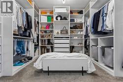 Custom closet system featuring extensive shelving, multiple hanging rods, integrated drawers, and a central storage bench - 
