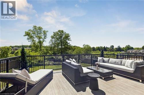 Expansive rooftop terrace featuring wood-finish decking, black metal railings, and clear glass panels - 95 Pondcliffe Drive, Kitchener, ON 
