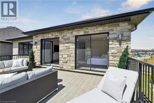 Expansive outdoor patio featuring composite decking, a stone-clad exterior, and a black metal railing - 95 Pondcliffe Drive, Kitchener, ON 