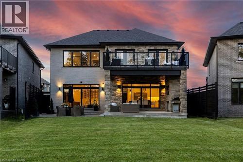 Expansive green lawn with a two-story residence featuring a stone and light-colored brick exterior - 95 Pondcliffe Drive, Kitchener, ON 