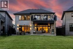 Expansive green lawn with a two-story residence featuring a stone and light-colored brick exterior - 