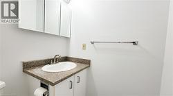 White bathroom vanity with an oval basin, granite-finish countertop, brushed nickel faucet, and a wall-mounted mirrored medicine cabinet - 