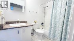 Bathroom featuring a vanity with a composite countertop, undermount sink, and brushed nickel faucet - 