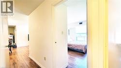Hallway featuring wood-finish flooring and white baseboards - 