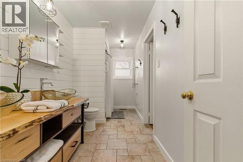 Bathroom featuring a live-edge wood vanity with an amber vessel sink, chrome faucet, and mirrored medicine cabinet - 17 Piper Place, Caledonia, ON 