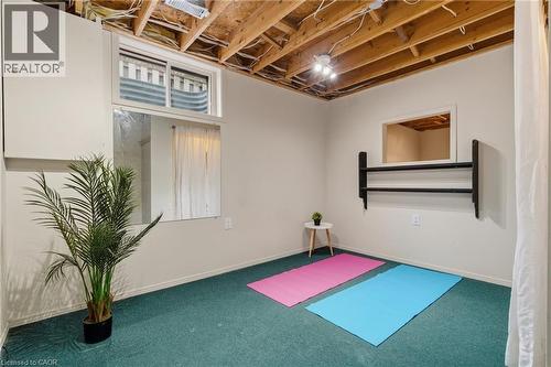 Carpeted room featuring an exposed beam ceiling, recessed window, and white painted walls - 17 Piper Place, Caledonia, ON 