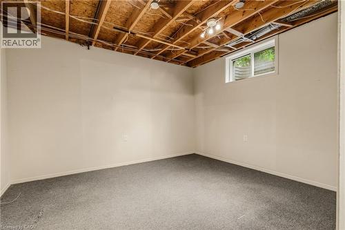 Basement space featuring light-colored walls, gray carpet, and an exposed wood ceiling - 17 Piper Place, Caledonia, ON 