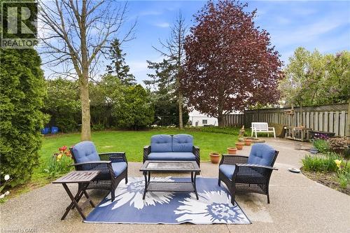 Expansive concrete patio area with a manicured lawn - 17 Piper Place, Caledonia, ON 