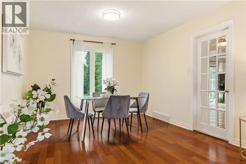 Dining area featuring wood-finish flooring, a window with exterior views, and a glass-paneled door - 17 Piper Place, Caledonia, ON 