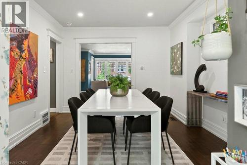 Dining area featuring dark wood-finish flooring, white baseboards, and crown molding - 99 Hillcrest Avenue, Hamilton, ON 