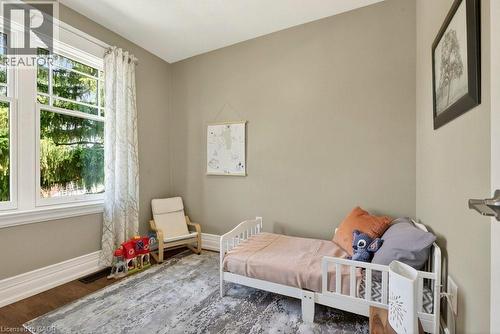 Neutral-toned room featuring a large multi-pane window with white trim, wood-finish flooring, and white baseboards - 99 Hillcrest Avenue, Hamilton, ON 