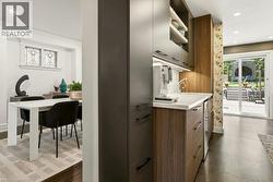 Integrated beverage station featuring a countertop sink, under-cabinet lighting, and built-in refrigerator - 