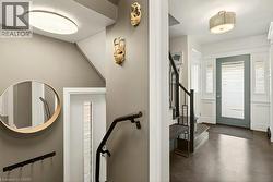 Entryway featuring a solid wood door with frosted glass paneling, surrounded by white wainscoting and sidelight windows - 
