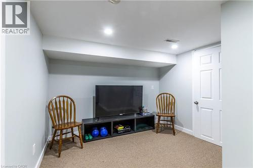Finished lower level with recessed lighting, light neutral wall paint, and durable carpeting - 20 West 1St Street, Hamilton, ON 