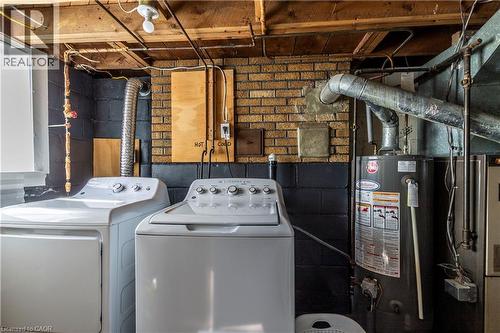 Laundry area featuring a top-load washing machine, a front-load dryer, and a water heater - 20 West 1St Street, Hamilton, ON 
