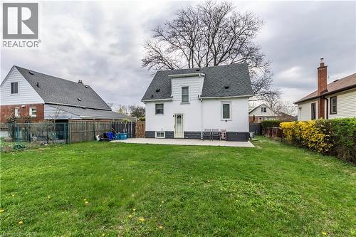 Expansive green lawn with a concrete patio extending from the rear of the home - 20 West 1St Street, Hamilton, ON 