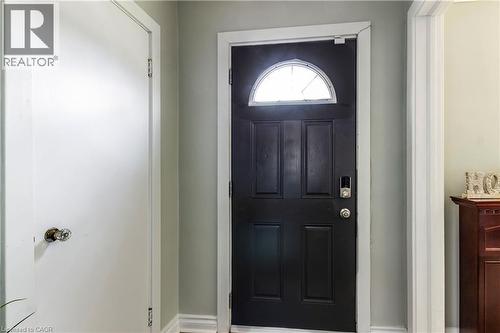 Black paneled entry door with an arched transom window and digital keypad entry - 20 West 1St Street, Hamilton, ON 