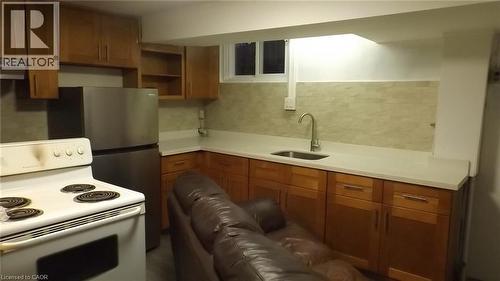 Kitchenette featuring wood-finish cabinetry, light-toned countertops, a stainless steel refrigerator, and a white electric range - 68 Austin Drive, Waterloo, ON - Indoor Photo Showing Kitchen