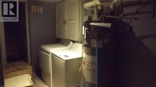 Utility area featuring a top-load washer, a front-load dryer, and upper cabinetry - 68 Austin Drive, Waterloo, ON - Indoor Photo Showing Laundry Room